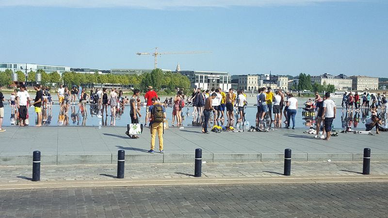 Lots of people wading in a reflecting pool