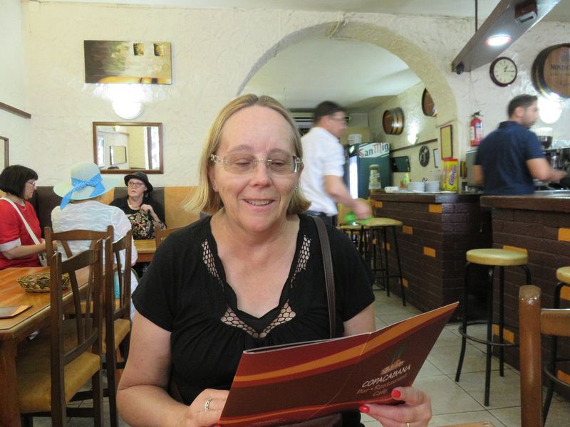 June reads the menu at the Copacabana