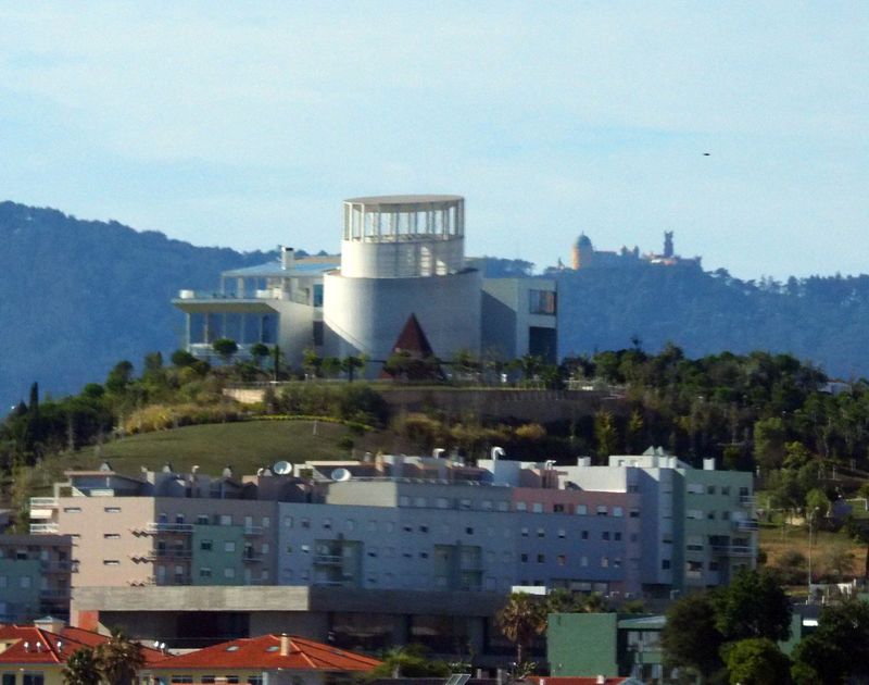 A modern building with the Pena Palace in the background