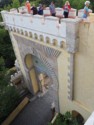 Eloise stands next to the crenellations over the gate