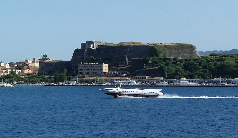 A hydrofoil boat speeds past the New Fortress