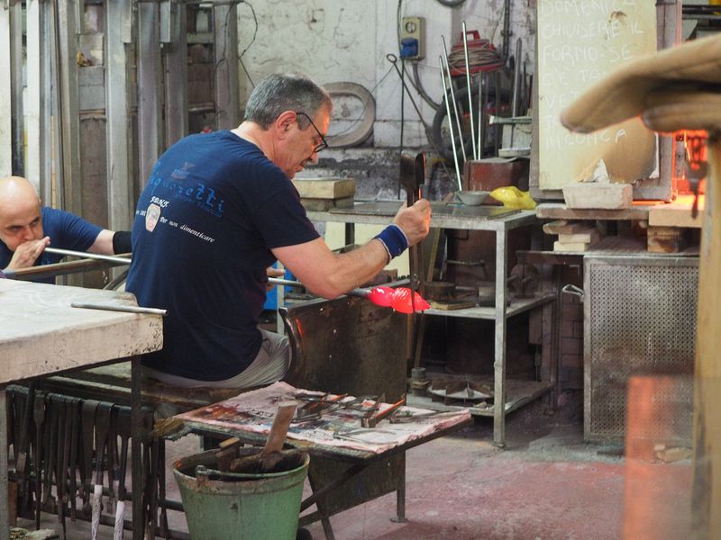 Master craftsmen work with molten glass