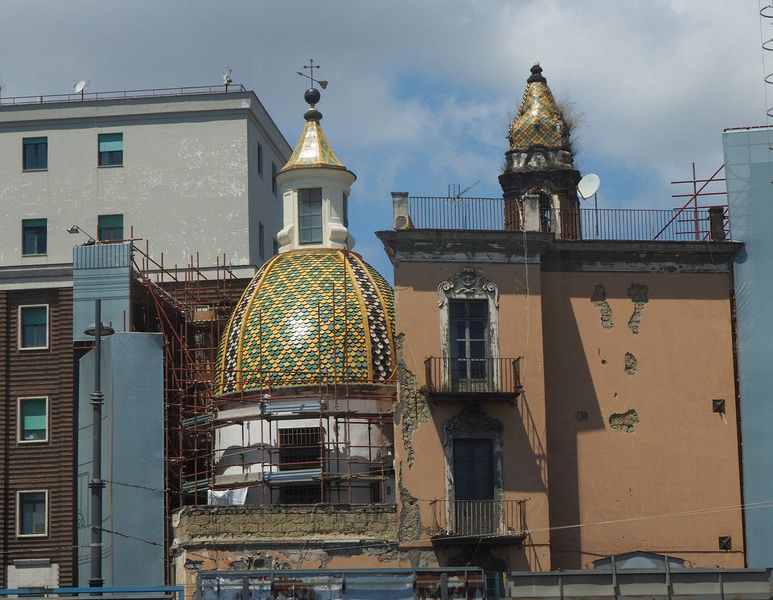 A tiny church nestled amongst some buildings