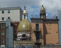 A tiny church nestled amongst some buildings