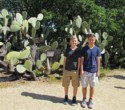Nicholas and Andrew next to some huge cacti on the grounds of the mission
