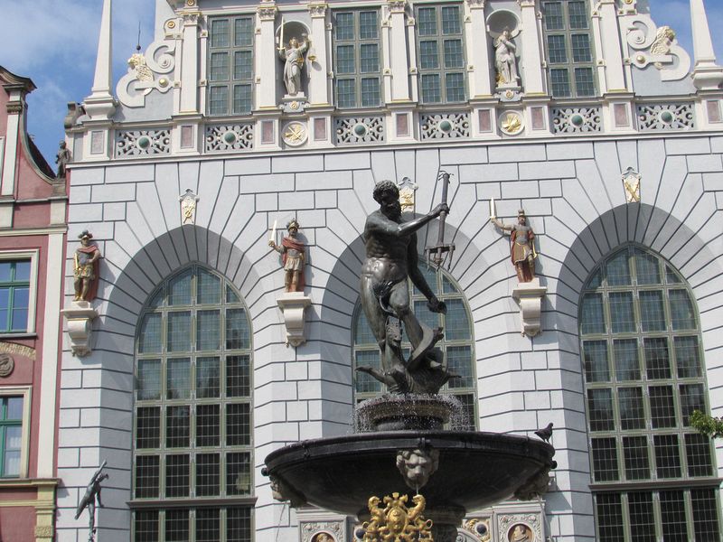 Neptune's Fountain in front of a building with statues