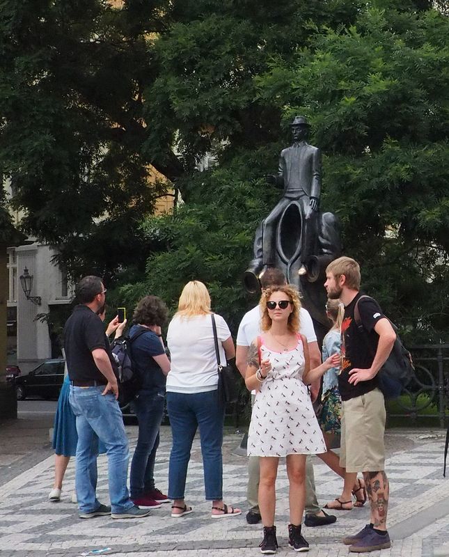 People view a status of Franz Kafka astride a headless man