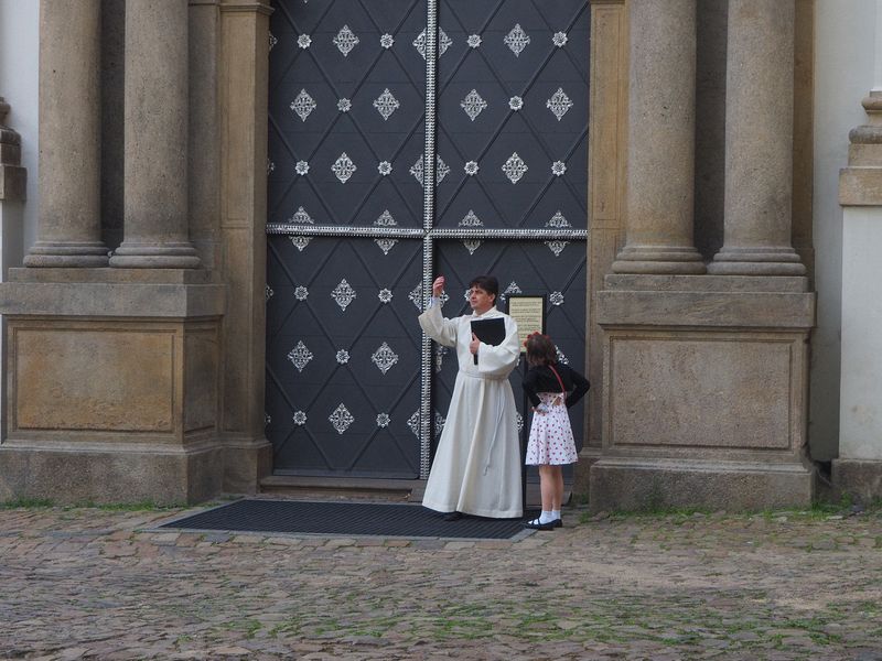 The little girl doesn't seem to be happy with the priest