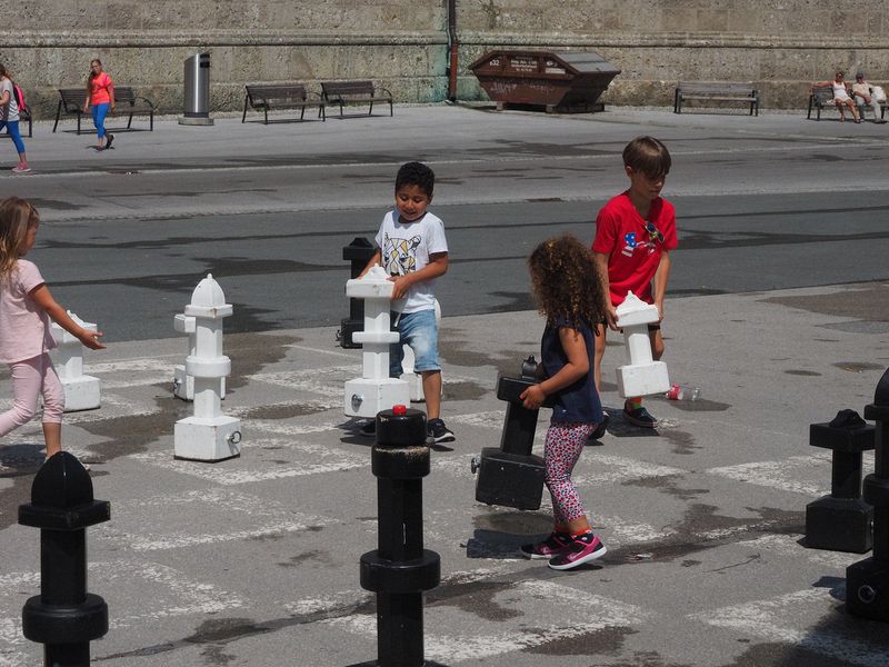 Kids moving giant chess pieces