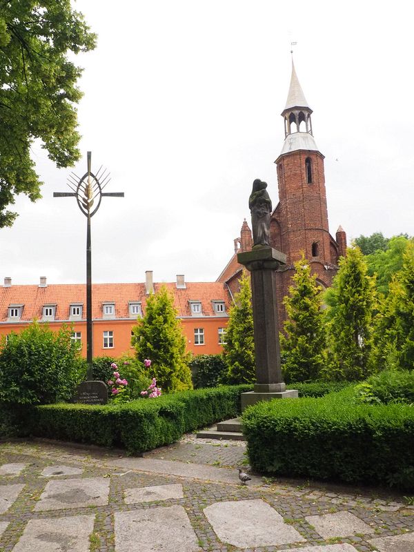 Cross honoring the bishop and a statue of Mary