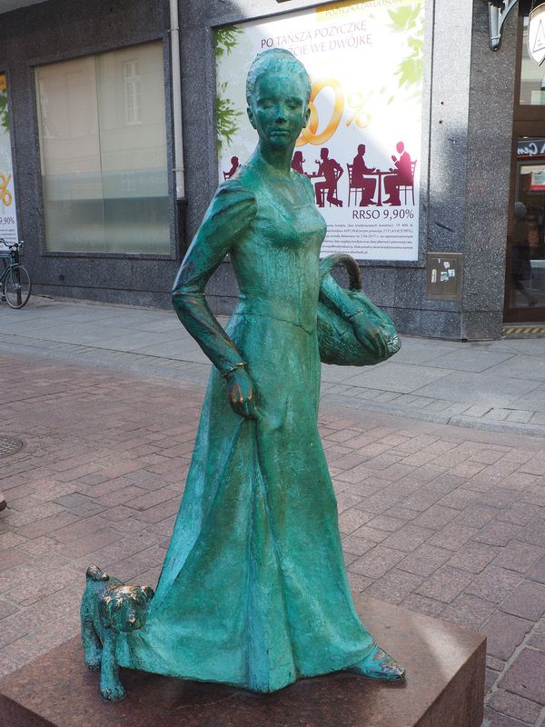 Statue of dog pulling on woman's dress