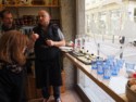 The shop owner explains French cheeses