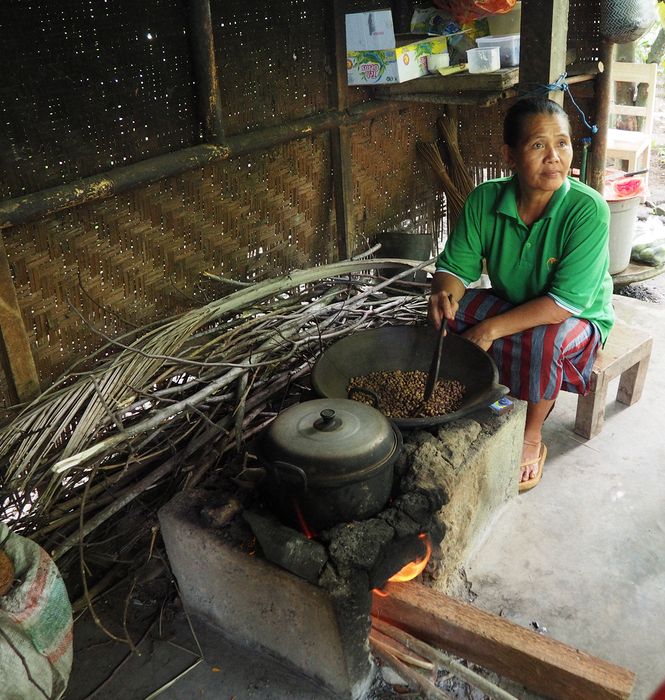 A woman roasting coffee in a wok