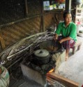 A woman roasting coffee in a wok