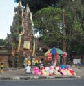 Colorful teddy bears for sale next to a shrine