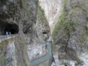 The road weaves through tunnels along the gorge