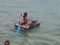 A little kid paddles from a piece of styrofoam