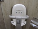 A baby seat in the toilet stall