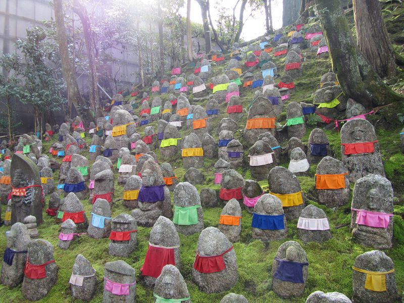 Dozens of Jizo with colorful bibs