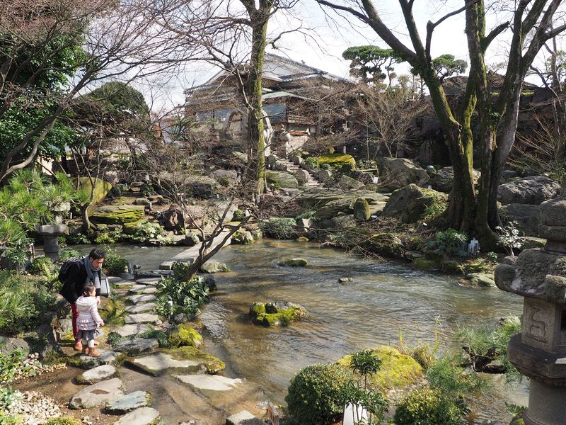 A man walks with his daughter next to the stream