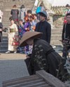 A woman in black robes and rice paddy hat