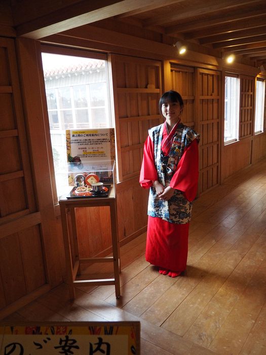 A staff member in kimono advertises a tea ceremony