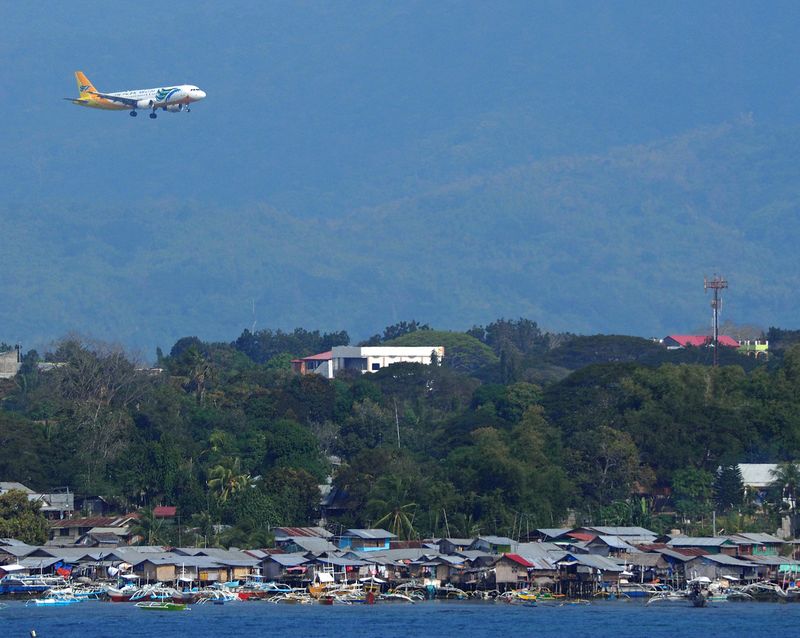 A plane comes in for a landing behind the water village