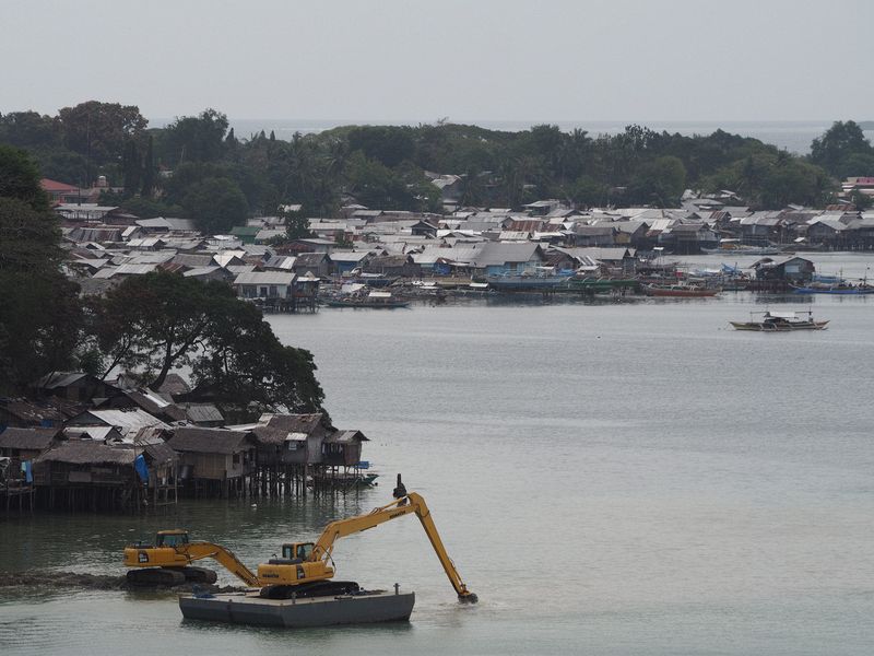 Dredging next to a water village