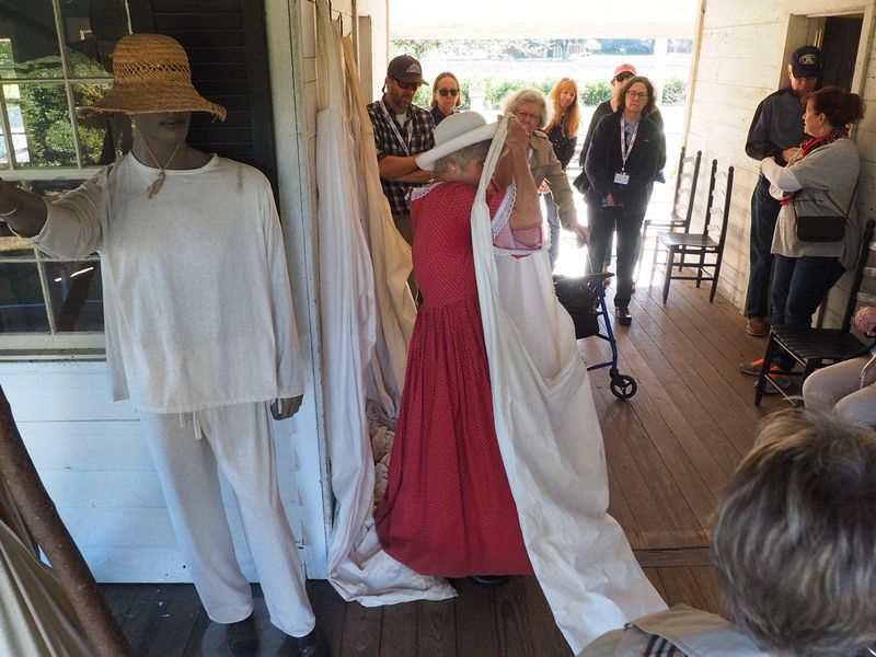 Our guide demonstrates a harvest bag next to mannequin dressed for picking