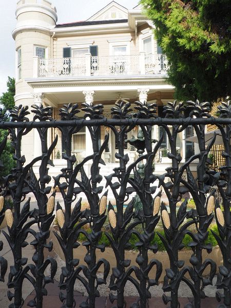 Ironwork fence with corn stalks