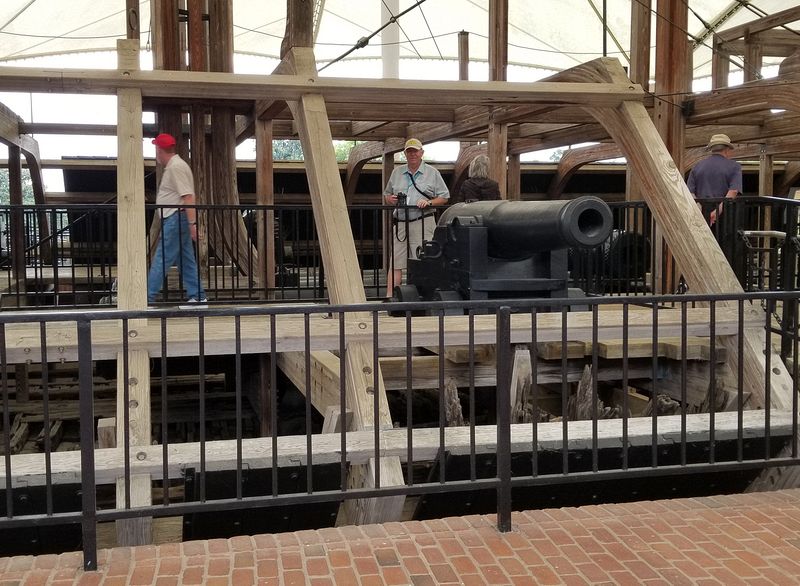 Pete next to a cannon inside the framing for the ironclad riverboat