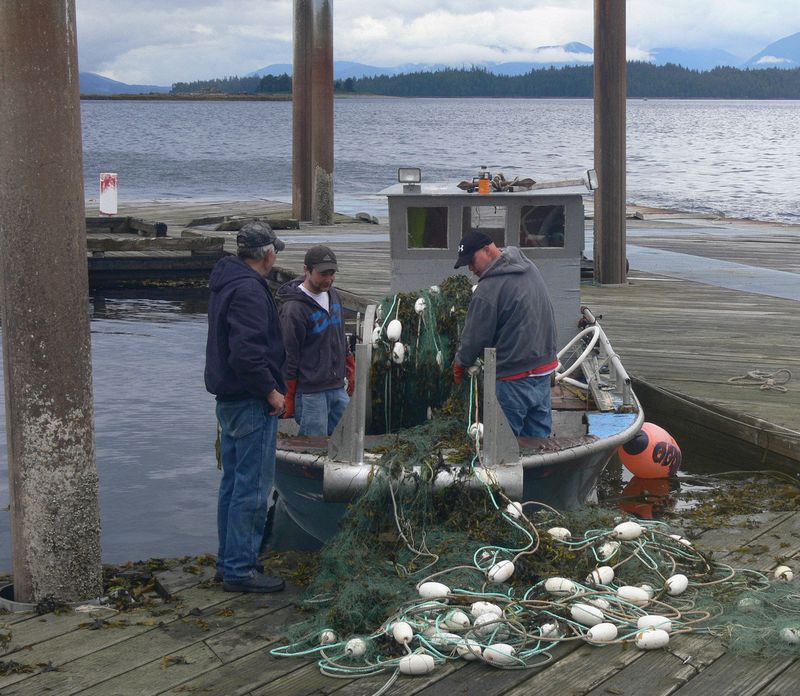 Fisherman load a net onto their boat