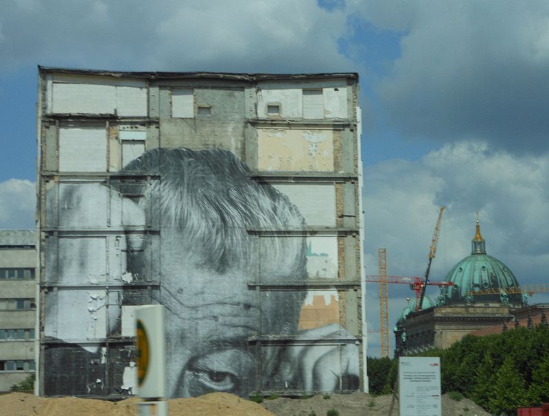 Huge photo on side of a partly demolished building