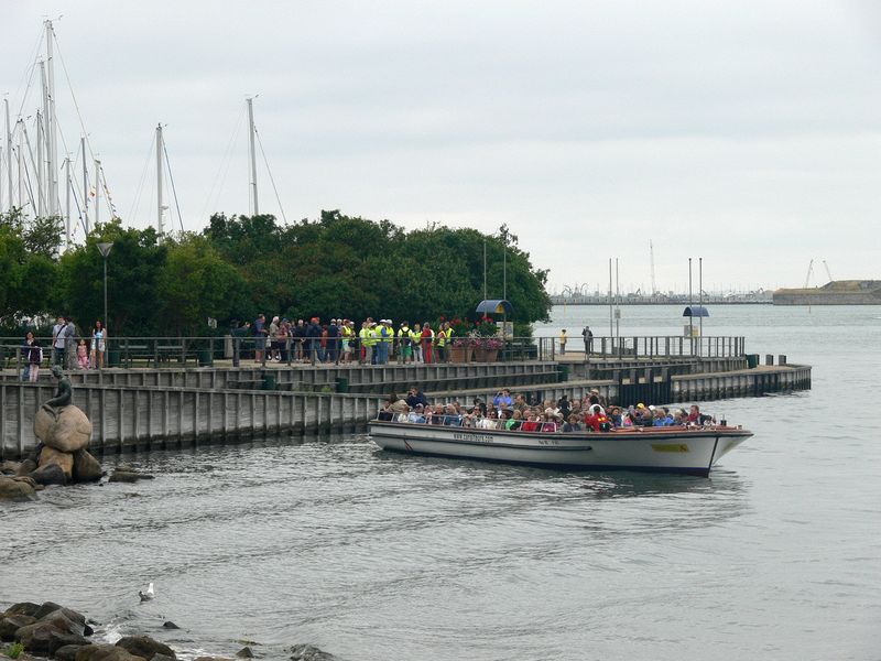 A tour boat pulls in close to see the statue