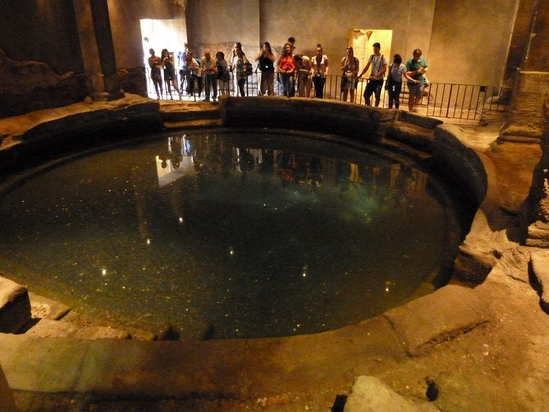 People throw coins in the circular bath