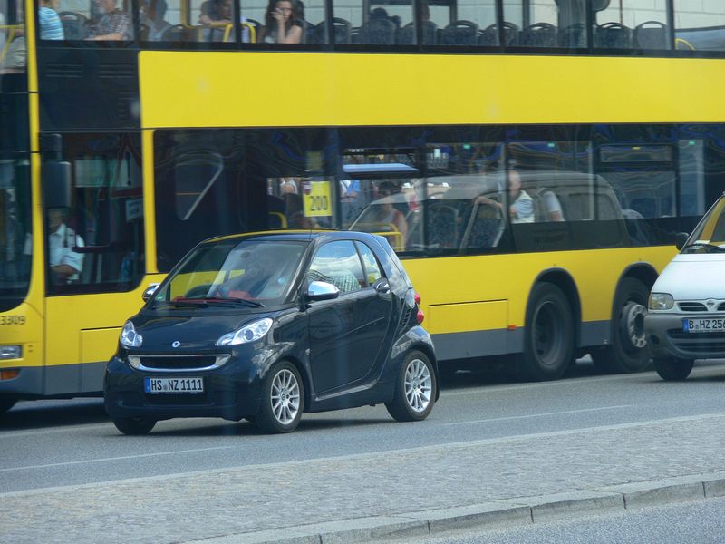 Smart next to a bus