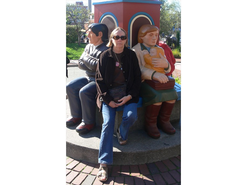 June sits next to carved statues