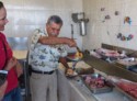 The shop owner pulls a sea snail out of its shell to show us