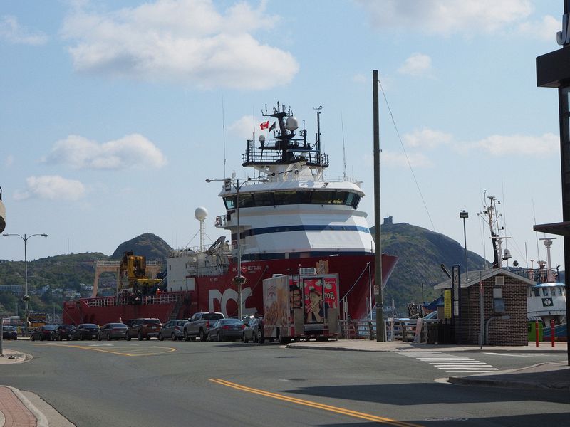 A big fishing boat is docked right downtown