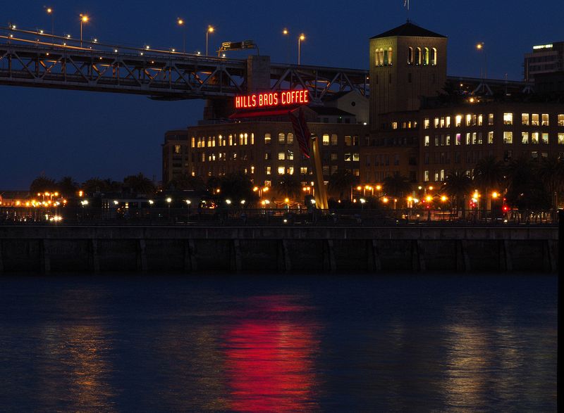 Building lights reflect red on the water