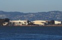Buildings on Treasure Island with Pelicans in foreground and Oakland Hills in background