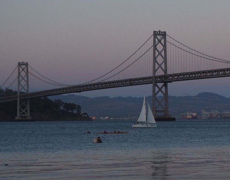 Kayaks and sailboat at dusk