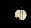 Silouette of a truck driving past the moon on the Bay Bridge