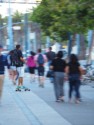 Skate boarder moving fast amongst the pedestrians