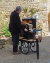 A man playing a crank organ