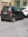 A Smart Car jammed into a tiny parking spot