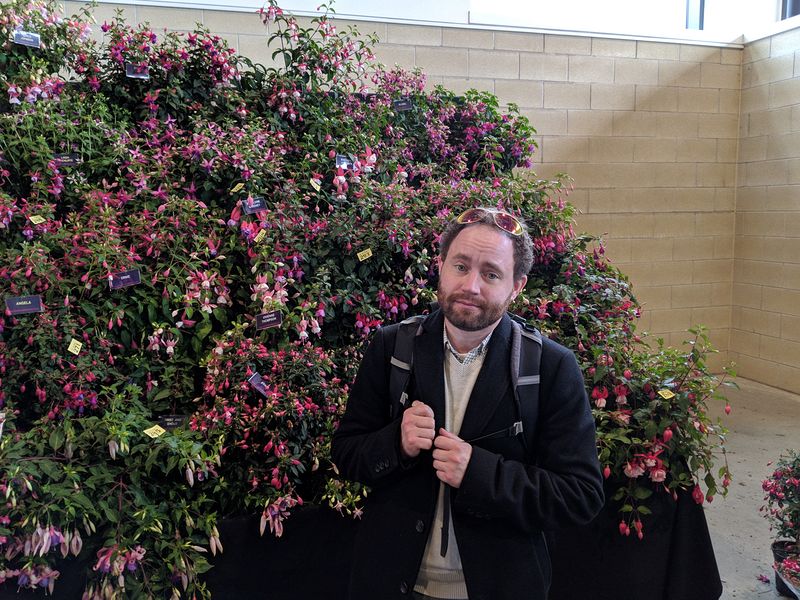 Ehren next to a wall of flowers